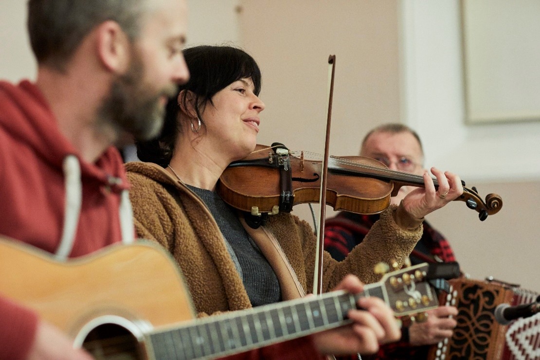 Musicians on guitar and fiddle and accordion