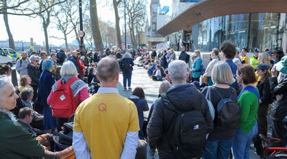A long thin meeting for worship outside New Scotland Yard with Big Ben (Elizabeth Tower) in the background