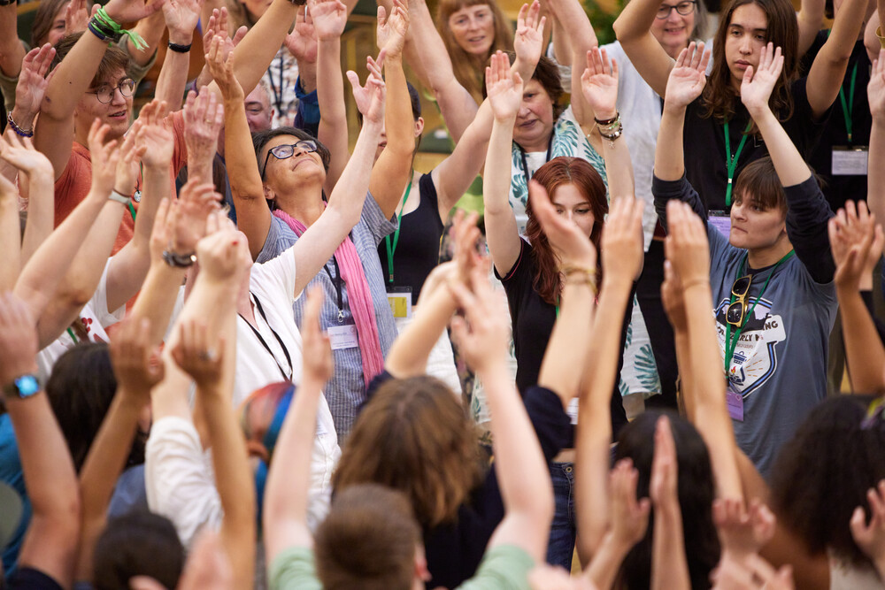 A group of people standing around together with their hands in the air