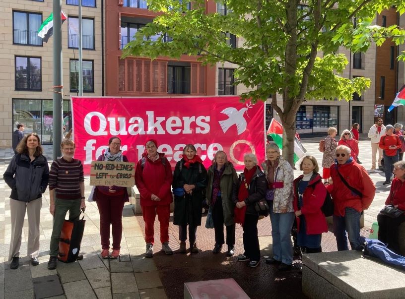People wearing red in front of Quakers for Peace banner