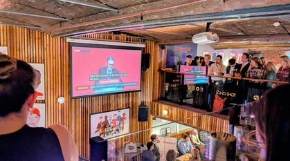 Delegates and attendees of the Labour Party conference watch Keir Starmer's speech on a big screen.