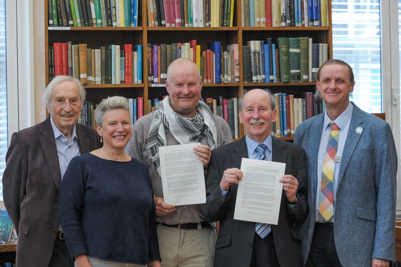Five people in a row in front of books