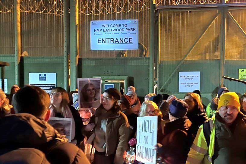 Prison entrance at night with candle lit vigil