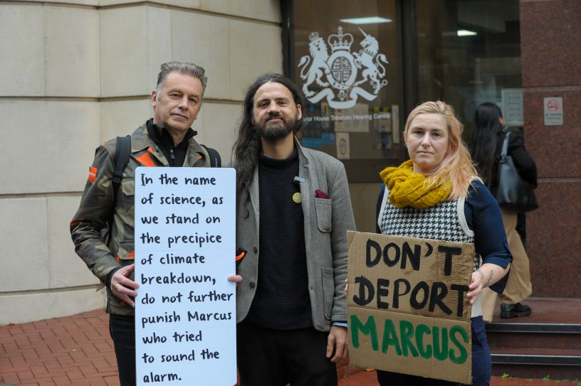Three people with placards