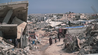 In Gaza, people walk among ruined buildings