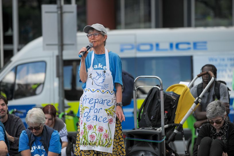 Woman speaking into microphone in front of police van